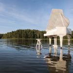 Grand white piano set in a lake